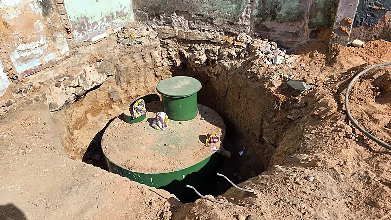 Tanque em PRFV verde sendo assentado em vala para instalação enterrada