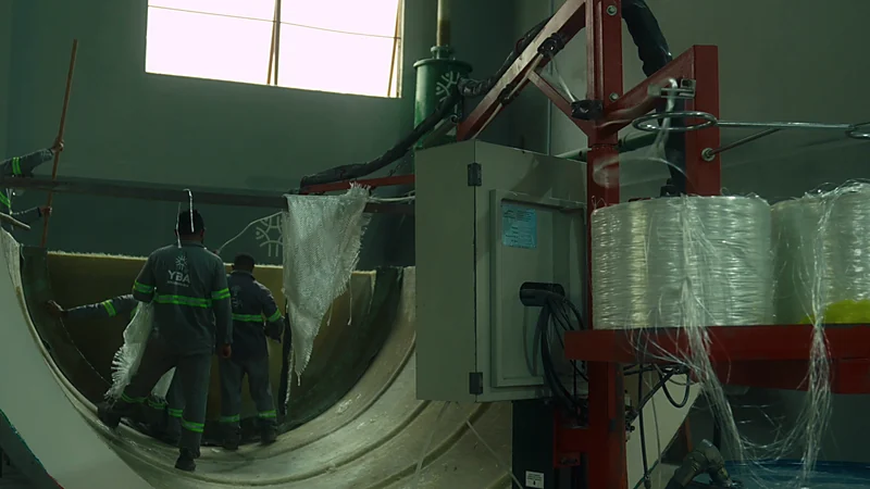 Equipe da fábrica laminando o interior de um casco por spray-up, com fibra de vidro picada e resina