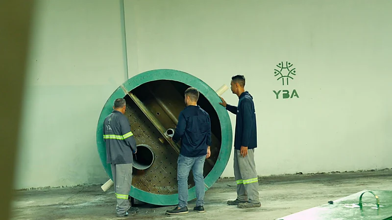 Técnicos da YBA inspecionando o interior de um casco de tanque na fábrica