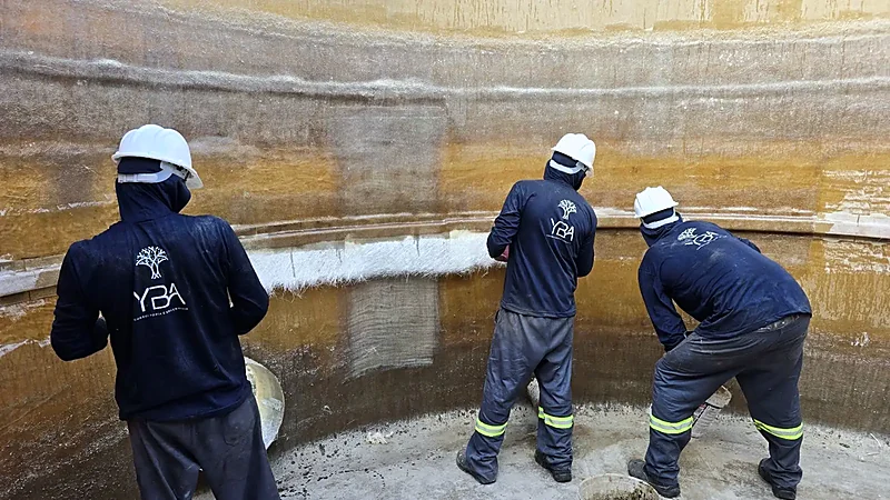Técnicos laminando o interior de um reator