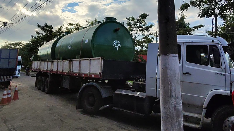 Caminhão com tanque de PRFV verde a caminho da obra