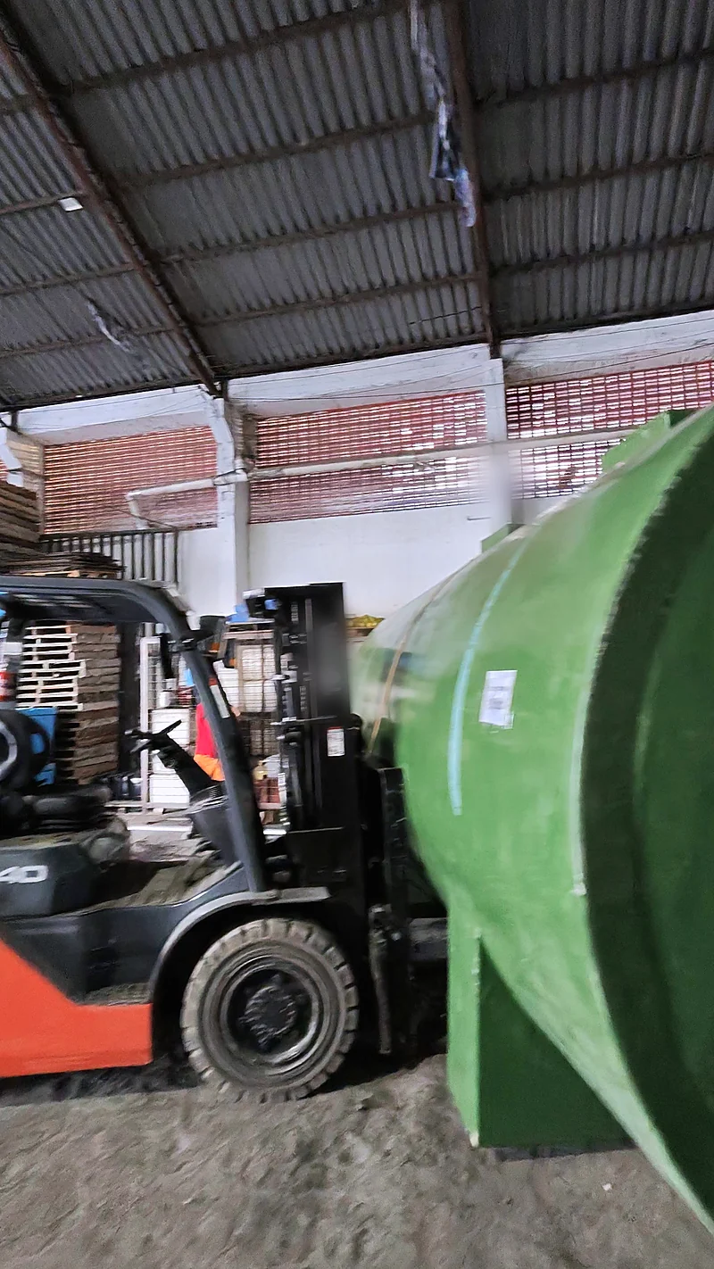 Empilhadeira movimentando um tanque de PRFV no galpão